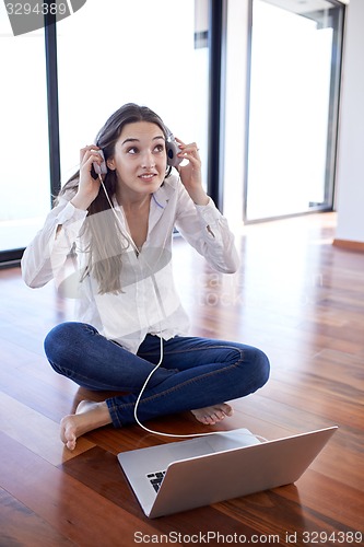 Image of relaxed young woman at home working on laptop computer