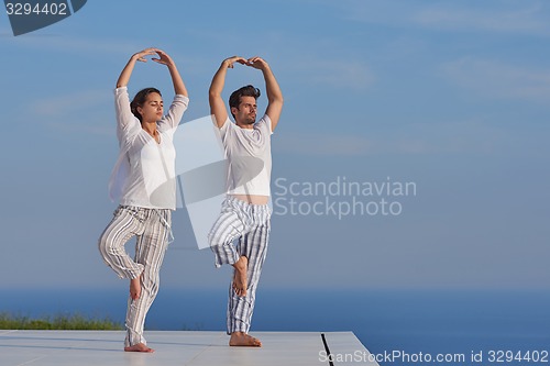Image of young couple practicing yoga