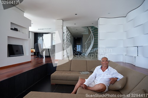 Image of Portrait of senior man relaxing in sofa