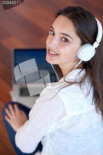 Image of relaxed young woman at home working on laptop computer