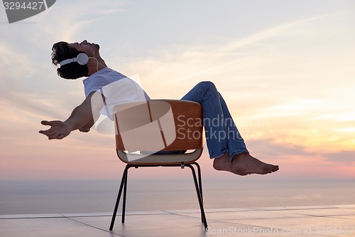 Image of relaxed young man at home on balcony