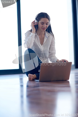 Image of relaxed young woman at home working on laptop computer