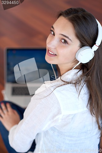 Image of relaxed young woman at home working on laptop computer