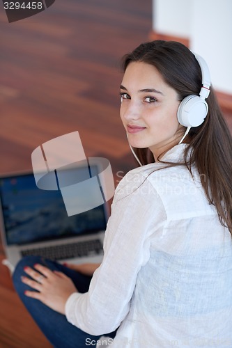 Image of relaxed young woman at home working on laptop computer