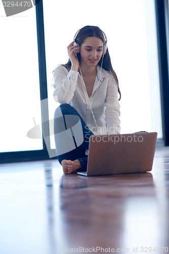 Image of relaxed young woman at home working on laptop computer