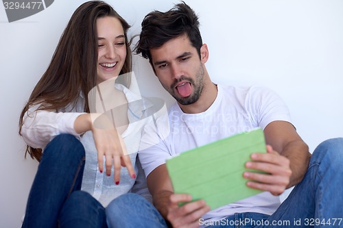 Image of couple at modern home using tablet computer