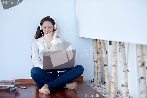 Image of relaxed young woman at home working on laptop computer