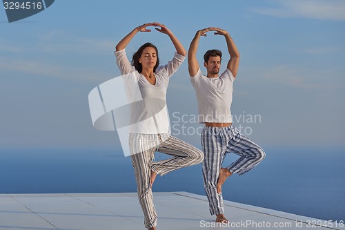 Image of young couple practicing yoga