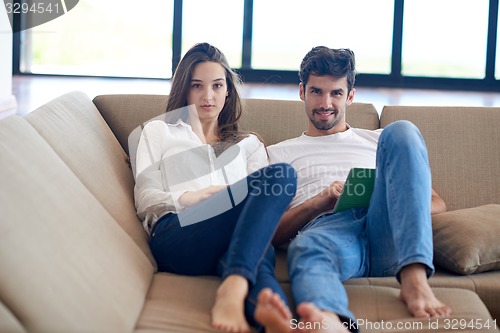 Image of couple at modern home using tablet computer