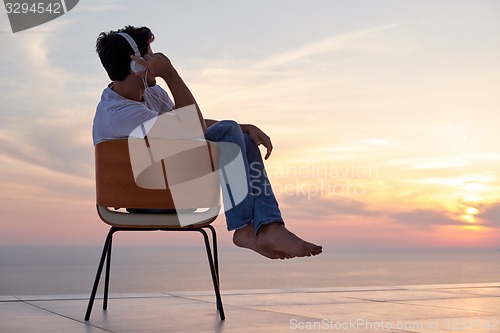 Image of relaxed young man at home on balcony