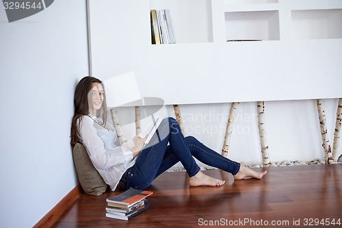 Image of relaxed young woman at home working on laptop computer