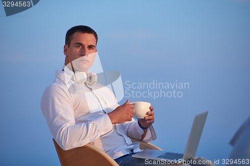Image of relaxed young man at home on balcony