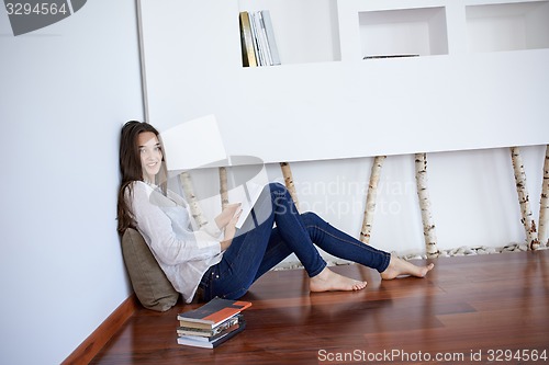 Image of relaxed young woman at home working on laptop computer