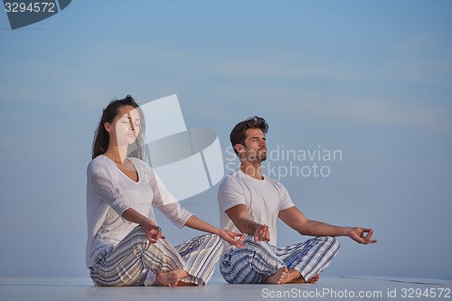 Image of young couple practicing yoga