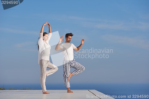 Image of young couple practicing yoga