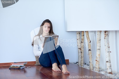 Image of relaxed young woman at home working on laptop computer
