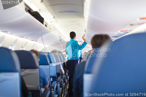 Image of Interior of airplane with passengers on seats.