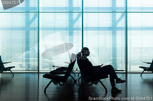 Image of Woman in transit waiting on airport gate.