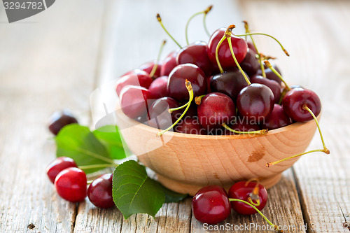 Image of Wooden bowl with ripe cherries.