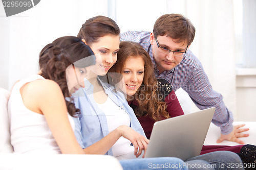 Image of four students and a notebook