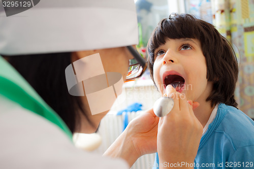 Image of boy showing his throat to doctor