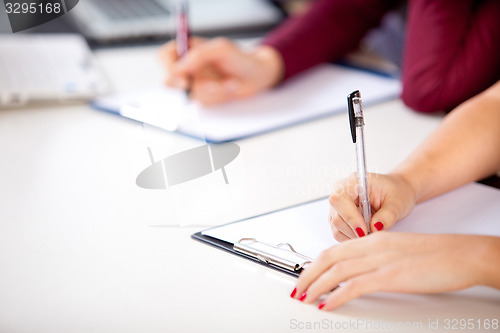 Image of woman holding a written examination