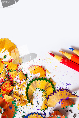 Image of set of colored pencils and shavings on white