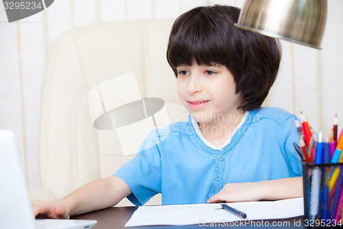 Image of boy doing homework with computer