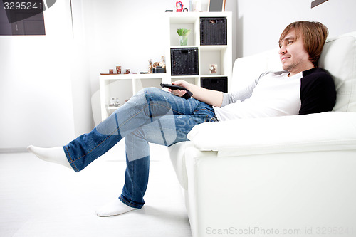 Image of smiling  man  with remote control tv