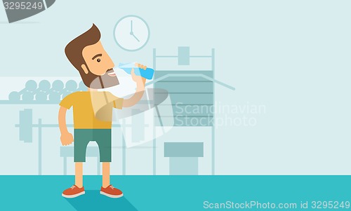 Image of Gentleman drink a bottle of water while inside the gym.