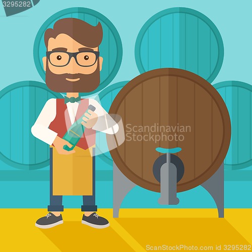 Image of Wine maker inspecting wine from barrel.