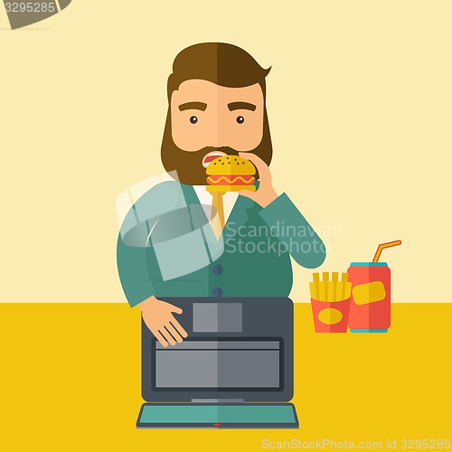Image of Young fat guy eating while at work.
