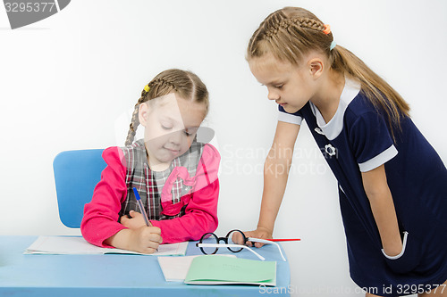 Image of Teacher student leaning on a table looking notebook