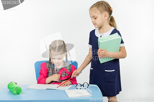 Image of Girl teacher found a mistake in the student notebooks