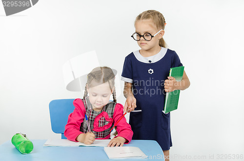 Image of Girl teacher supervises the job apprentice