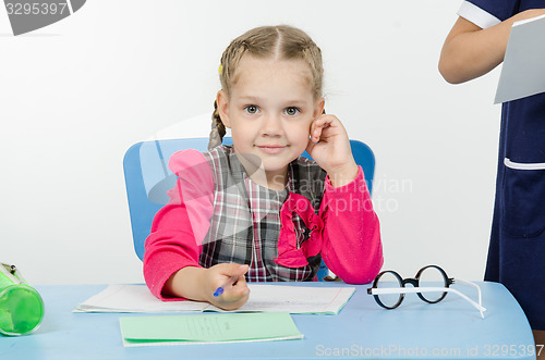 Image of Charming schoolgirl at the desk