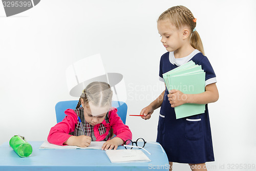 Image of Girl teacher stands at the student desk