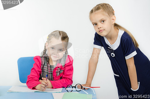 Image of The teacher leaned on table student