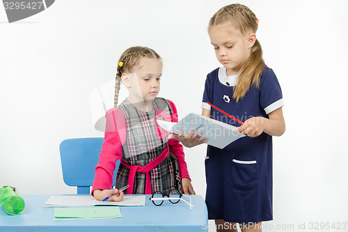 Image of The teacher looks at pupils diary