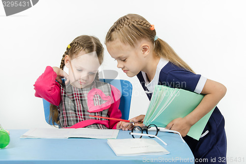 Image of Girl teacher checks written by a disciple