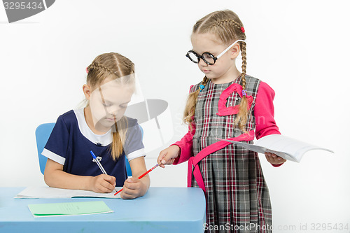 Image of The teacher points to a pointer in the notebook student