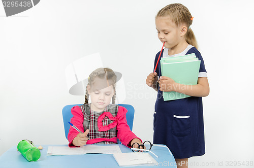 Image of Girl teacher enthusiastically looking at the notebook student