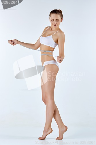 Image of Woman holding meter measuring perfect shape of her beautiful body 