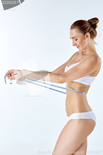 Image of Woman holding meter measuring perfect shape of her beautiful body 