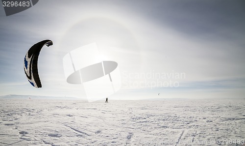 Image of Kiteboarder with blue kite on the snow