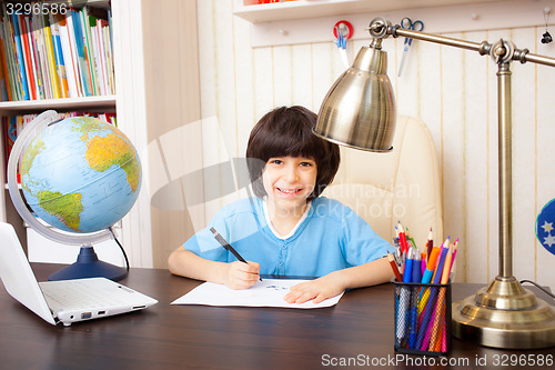 Image of smiling schoolboy doing homework