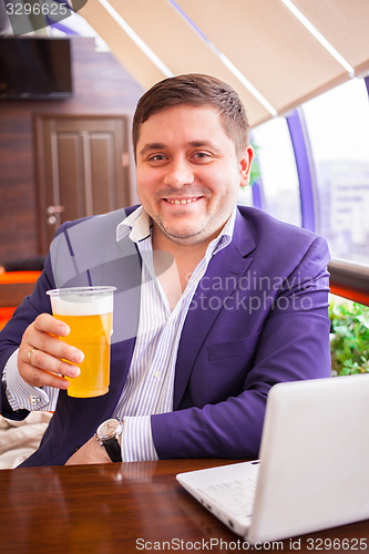 Image of smiling businessman with beer