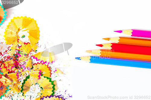 Image of colored pencils and shavings on white background