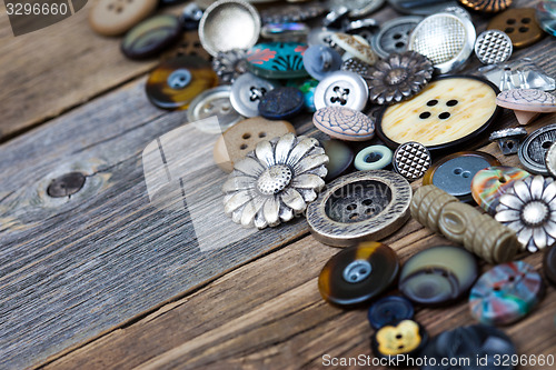 Image of old buttons in large numbers scattered on aged wooden boards
