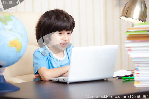 Image of smiling boy looking at a computer monitor